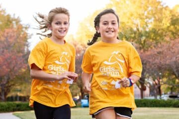 Two girls in Girls who Run shirts running